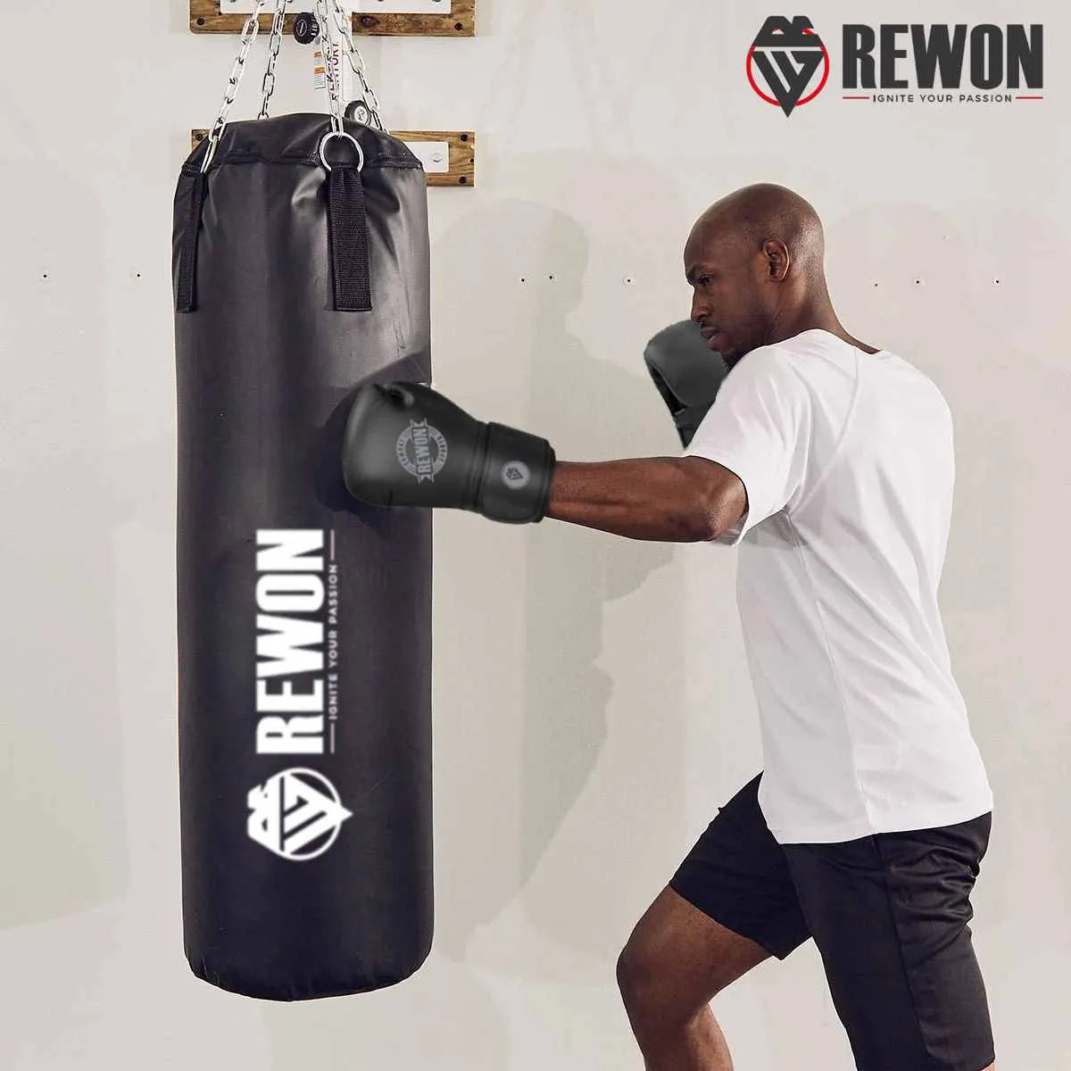 Man using Rewon black boxing gloves on heavy bag; ideal for kickboxing and MMA training. Fitness and boxing gear available online.