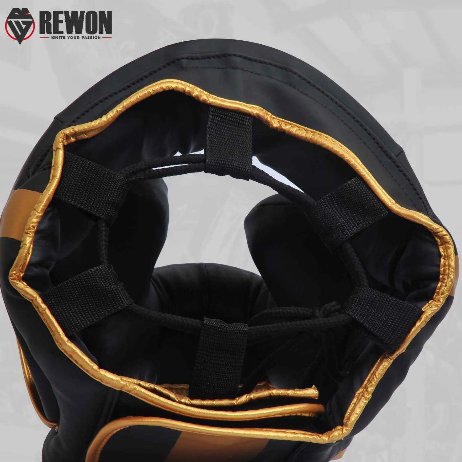 Golden and black Rewon boxing headgear for MMA and kickboxing, featuring full face and head protection. Ideal training accessory.