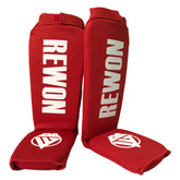 Red Rewon shin guards for kickboxing and Muay Thai, featuring adjustable straps for a secure fit and comfort during training.