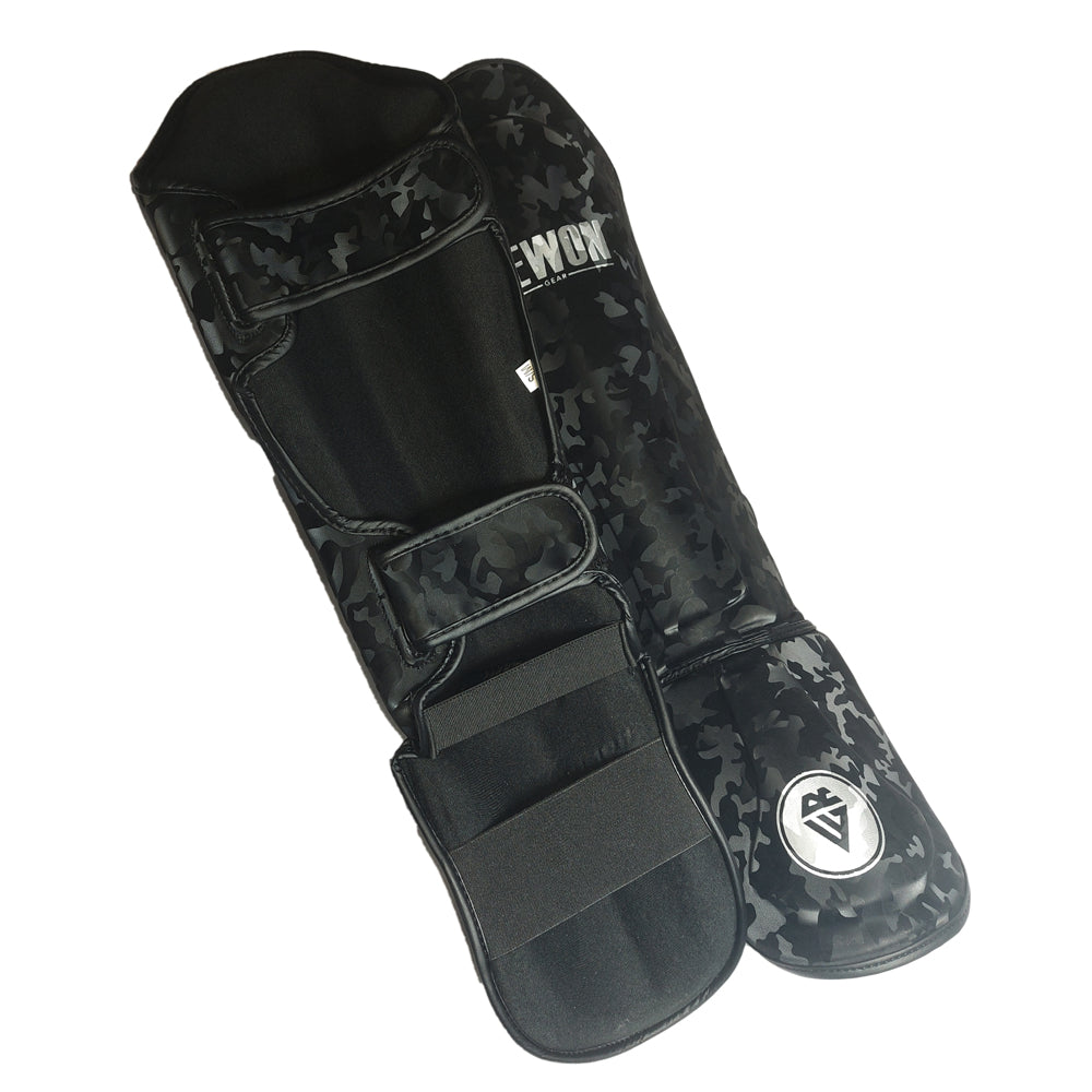 Night Camo Rewon shin guards for kickboxing and MMA in black camouflage design, featuring secure Velcro straps and comfortable fit.