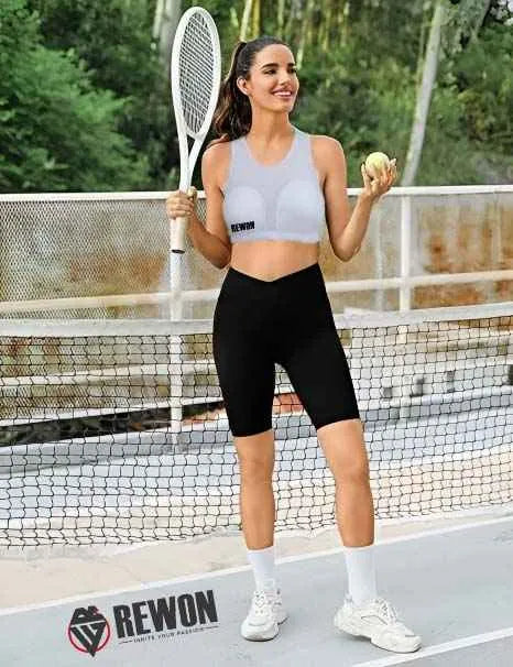 Woman in black shorts and grey sports bra holding a tennis racket on a court, showcasing Rewon sportswear.